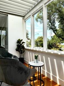 a room with a chair and a table and windows at Luxury stay in Williamstown in Williamstown