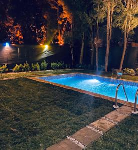 a swimming pool in a yard at night at Four seanson müstakil sıcak havuzlu villa in Sapanca