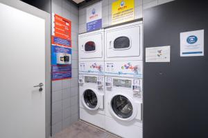 due lavatrici e asciugatrici in una stanza di harry's XL Hotel a Salisburgo