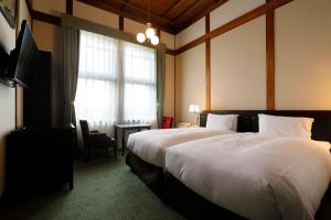 奈良市にある奈良ホテルの大型ベッドとテレビが備わるホテルルームです。