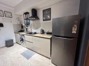 a kitchen with a stainless steel refrigerator and a dishwasher at European studio apartment at Hiranandani thane in Thane