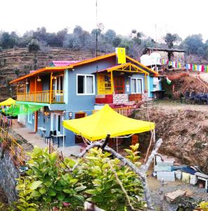 una casa colorida con sombrillas delante en BUNK CHAMBER en Mukteswar