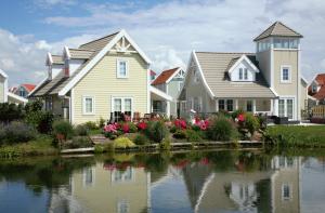 una fila de casas junto a un lago en Summio Duynparc De Heeren van 's-Gravensande en Vluchtenburg