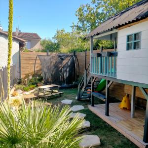 a backyard with a tiny house with a deck at Belle Grange Rénovée 10 couchage + 1 bébé in Pavie