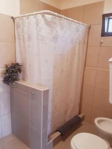 a shower curtain in a bathroom with a toilet at Cabañas Alma del Sur in El Hoyo