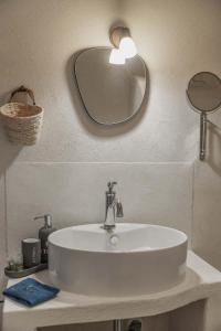 la torre boutique rooms في بروسيدا: حوض حمام أبيض مع مرآة على الحائط