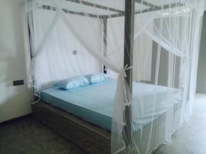 ヒッカドゥワにあるVilla Conch by Om - Private House - Hikkaduwaのベッドルーム(白いカーテン付きの天蓋付きベッド1台付)