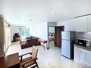 uma cozinha e sala de estar com um sofá e um frigorífico em Nanthana Villa em North Pattaya