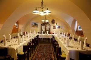 a long dining room with white tables and chairs at Gasthof zum Goldenen Anker in Hainburg an der Donau