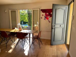 comedor con mesa, sillas y puerta en Villa proche d'Avignon., en Le Pontet