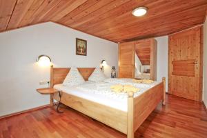 a bedroom with a large bed with a wooden ceiling at Wagnerhof in Au am Inn