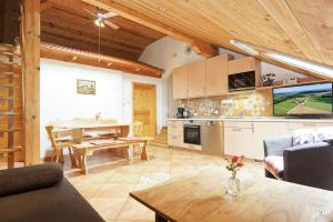 a kitchen and living room with a table and a dining room at Wagnerhof in Au am Inn