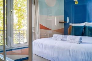 a bedroom with a bed with towels on it at Appartement coloré Wagram - II in Paris