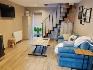 a living room with a blue couch and a staircase at MaisonnetteAu36-centre-parking-cosy in Angoulême