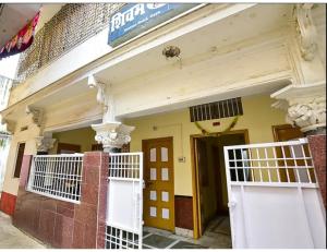 ein Gebäude mit weißen Türen und weißen Balkonen in der Unterkunft Shivam Guest House, Gaya in Gaya