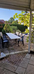 - une table de pique-nique et des chaises sur la terrasse dans l'établissement Ferienhaus Weilheim mit Garten Spiel und Spass, à Weilheim in Oberbayern