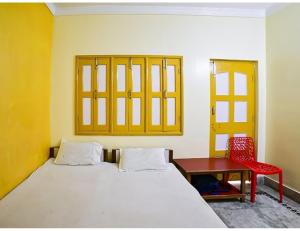 ein Schlafzimmer mit einem Bett, einem Tisch und einem Stuhl in der Unterkunft Shivam Guest House, Gaya in Gaya