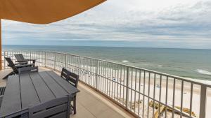 ein Balkon mit Tisch und Stühlen und dem Meer in der Unterkunft Phoenix Gulf Tower 1004 condo in Gulf Shores