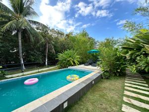 a swimming pool with two frisbees in a yard at Larue Pocket Villa in Calatagan