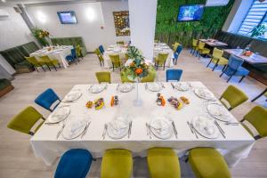 Hotel Corvaris في بوخارست: غرفة طعام مع طاولة بيضاء وكراسي