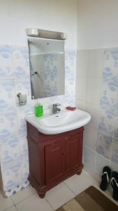 uma casa de banho com um lavatório e um espelho em Different Strokes Cottage em Diani Beach