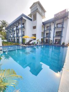 a large swimming pool in front of a hotel at The Upper House resort by J R high Sky in Morjim