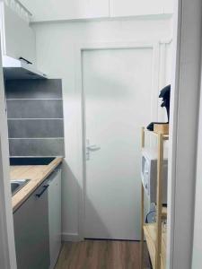 a white door in a kitchen with a sink at Le P'tit Stud' in Castres +1 photo