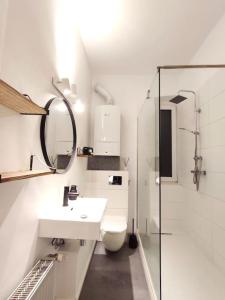 La salle de bains blanche est pourvue d'une douche et de toilettes. dans l'établissement 'BRIGHT 292' ruhige Wohnung 52qm, à Bielefeld