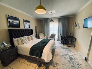 a bedroom with a large bed and a desk at Hatfield, Grosvenor Private apartment. in Pretoria