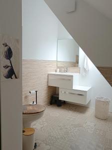 een badkamer met een wastafel, een toilet en een spiegel bij Direkt am Wald mit Panoramablick bis zur Pfalz in Laudenbach