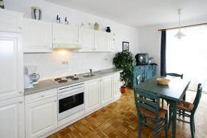 a kitchen with white cabinets and a table with chairs at Apartment in Boltenhagen near the sea in Boltenhagen