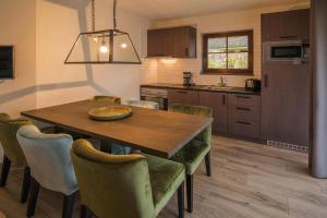 a kitchen and dining room with a wooden table and chairs at Holiday Resort Van der Valk, Linstow in Linstow