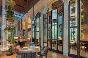 - un restaurant avec une table, des chaises et des fenêtres dans l'établissement Artyzen Singapore, à Singapour