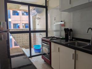 a kitchen with a sink and a stove top oven at bliss Haven spaces kileleshwa 2bedroom in Nairobi