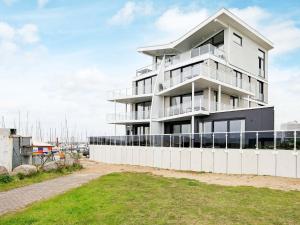 Ein weißes Gebäude mit einem Zaun davor. in der Unterkunft One-Bedroom Holiday home in Wendtorf 12 in Wendtorf