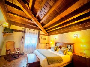 a bedroom with a large bed with a wooden ceiling at Posada Real de Carreteros in Casarejos
