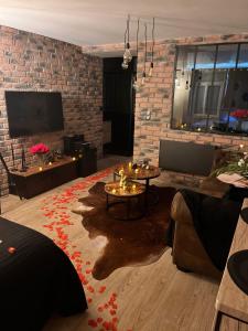 uma sala de estar com uma mesa e uma parede de tijolos em Just'un Instant em Landrecies