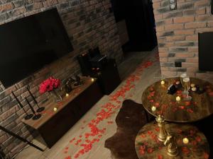uma sala de estar com televisão e uma mesa com velas em Just'un Instant em Landrecies