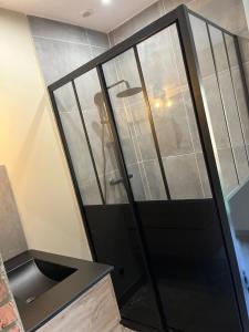 uma porta de vidro numa cozinha com um lavatório em Just'un Instant em Landrecies
