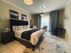 a bedroom with a large bed with a black headboard at Hatfield, Grosvenor Private apartment. in Pretoria