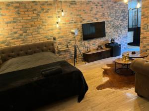 um quarto com uma cama e uma parede de tijolos em Just'un Instant em Landrecies