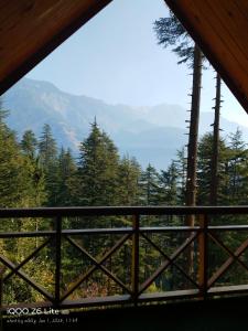 Cette cabine offre une vue sur les montagnes depuis sa fenêtre. dans l'établissement Forest View Cottage, à Jibhi