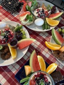 una mesa cubierta con platos de comida con frutas y hortalizas en Jurtta Linkkumylly, en Mäntyharju