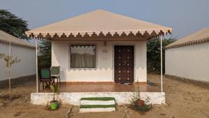 una pequeña casa blanca con techo marrón en Agvani Resort, en Bera