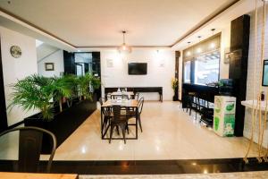 a dining room with a table and chairs and a television at RedDoorz Plus @ Jalan Raden Intan Lampung in Bandar Lampung