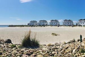 a group of houses on a beach with rocks at Apartment in Ostseeresort Olpenitz with balcony in Olpenitz