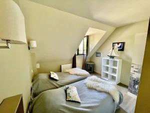 Duas camas num quarto com um sótão em Charmante Maison 400m du Golfe - Jacuzzi em Arradon