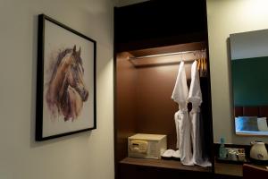 a bathroom with a picture of a horse on the wall at Legacy Hotel Bangkok Sukhumvit in Bangkok