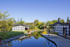 un jardín con un estanque y 2 edificios en Apartments at Van der Valk Resort, Linstow, en Linstow