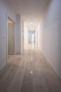 un couloir vide avec des murs blancs et du parquet dans l'établissement Le Stanze dell'Edera, à Bologne